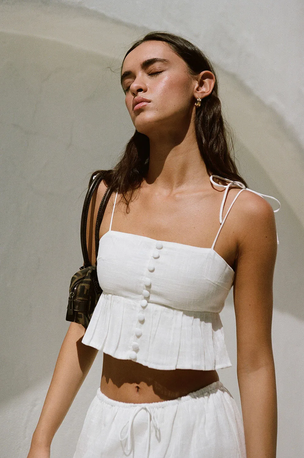 Drai Top putih bahan katun cheesecloth dengan tali bahu dan detail kancing depan eksklusif dari Joy368